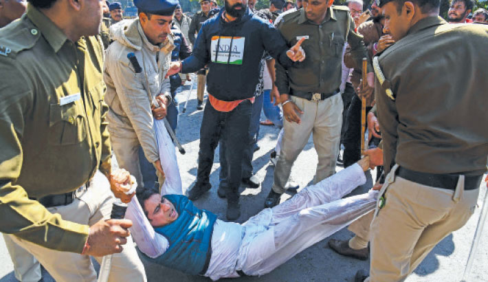 Activists of India’s Communist Party of India (Marxist) take part in a protest against the US government and President Donald Trump, in Hyderabad, Telangana, India on Sunday. Inset, police detain an activist from India's Congress party as they take part in a protest against the same issue, in Chandigarh on the same day. India's foreign minister threatened a "strong crackdown" on illegal migration on February 6, a day after a US military airplane flew back 104 migrants as part of President Donald Trump's overhaul of immigration.-AFP PHOTO
